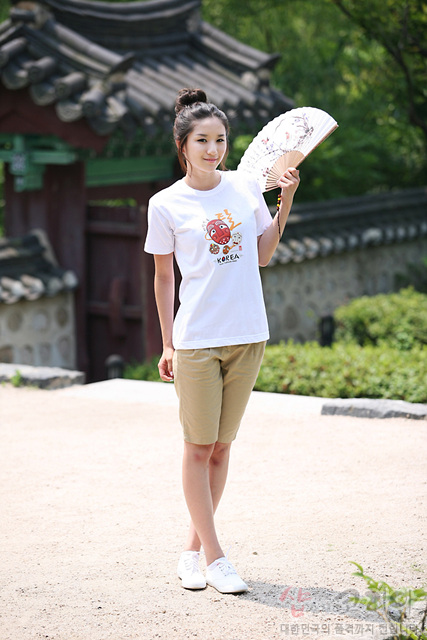 [텍스트: HAHOE MASK KOREA] 흰색 면 티셔츠 중앙 하회탈 캐릭터 3D 발포 프린트, 붉은색·갈색·검정색 조합 전통 가면 문양과 한글 캘리그래피 포인트 디자인