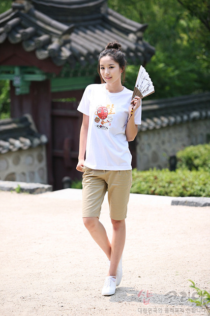 [텍스트: KOREA] 흰색 면 티셔츠에 하회탈 모티브 3D 발포 프린트와 붓글씨 풍 전통 한글 문양, 금색 포인트 그래픽이 더해진 캐주얼 반팔 디자인