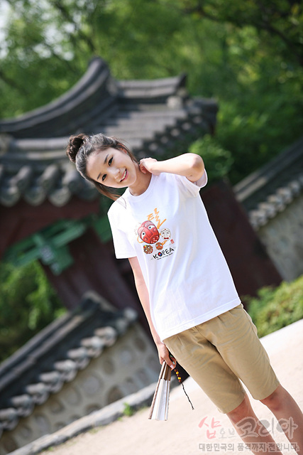 [텍스트: 탈 KOREA] 흰색 면 티셔츠 위 하회탈 캐릭터와 한글·영문 조합 3D 발포 프린트, 노랑·빨강 포인트 전통문양 그래픽 표현