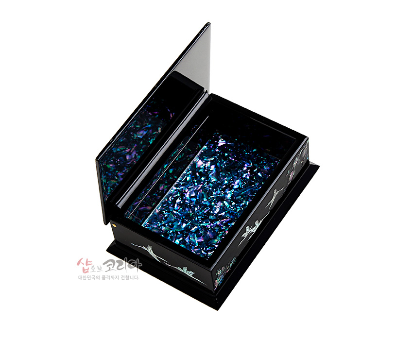 [텍스트: 샵오브코리아 대한민국의 품격까지 전합니다.] 흑색 옻칠 바탕 위에 자개 상감으로 학 문양을 둘레에 배치하고, 내부를 청록·보라색 조각 자개로 가득 채운 직사각형 나전칠기 명함함 이미지 설명