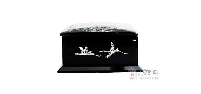 [텍스트: 샵오브코리아 대한민국의 품격까지 전달합니다.] 흑색 옻칠 바탕에 자개 상감 기법으로 두 마리 학을 표현한 직사각형 나전칠기 명함함 측면 장식 모습