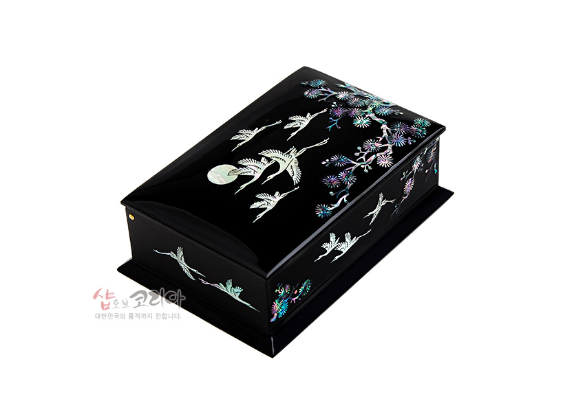 [텍스트: 샵오브코리아 대한민국의 품격까지 전합니다.] 흑색 옻칠 바탕 위 자개 상감 기법으로 달과 학, 국화와 소나무 문양을 배치한 직사각형 나전칠기 명함함 이미지 설명