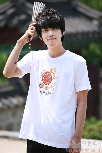 [텍스트: 탈 KOREA SHOP OF KOREA] 흰색 면 티셔츠 위 하회탈 일러스트와 한글 캘리그래피, 원형 전통 문양을 3D 발포 기법으로 표현한 그래픽 디자인