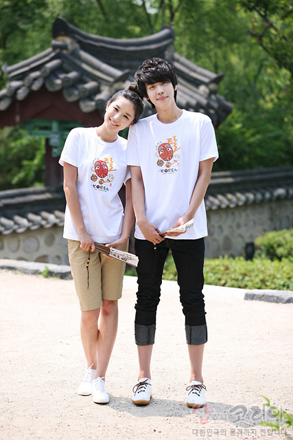 [텍스트: KOREA] 흰색 면 티셔츠에 하회탈 캐릭터와 한글 캘리그래피, 영문 조합 3D 발포 프린트가 돋보이는 전통 문양 반소매 디자인