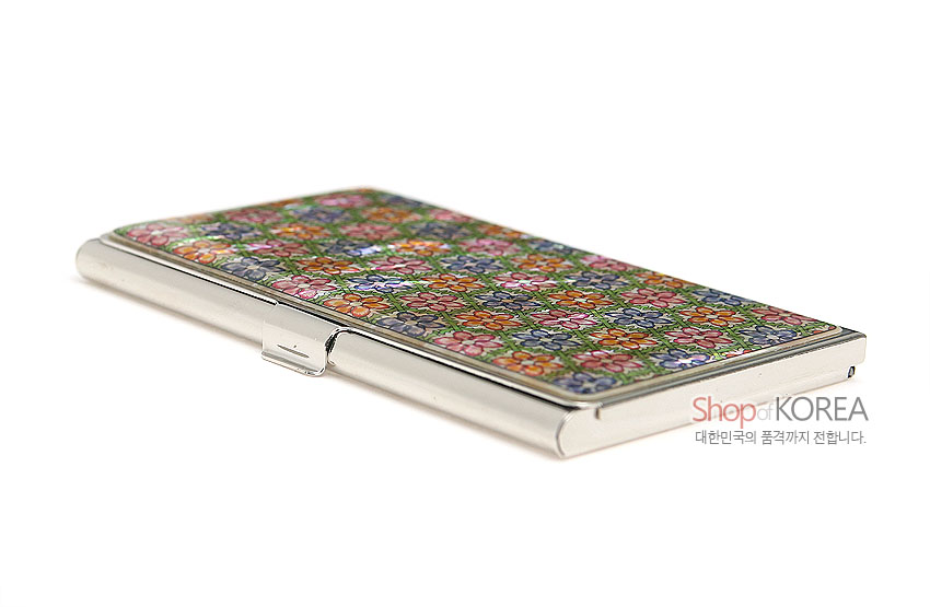 [텍스트: Shop of KOREA 대한민국의 품격까지 전합니다.] 금속 틀 위 자개 상감 기법으로 연두빛 바탕에 다채로운 꽃무늬가 촘촘히 배열된 직사각 명함 케이스 모습