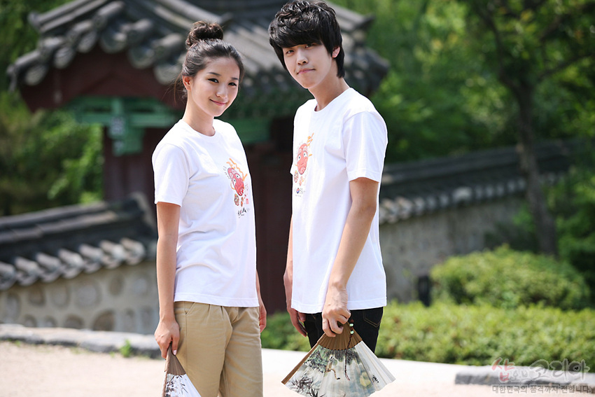 [텍스트: 하회탈] 흰색 면 티셔츠 위 전통 탈 캐릭터와 한글 조합 3D 발포 프린트, 밝은 색감의 일러스트가 돋보이는 캐주얼 반소매 디자인