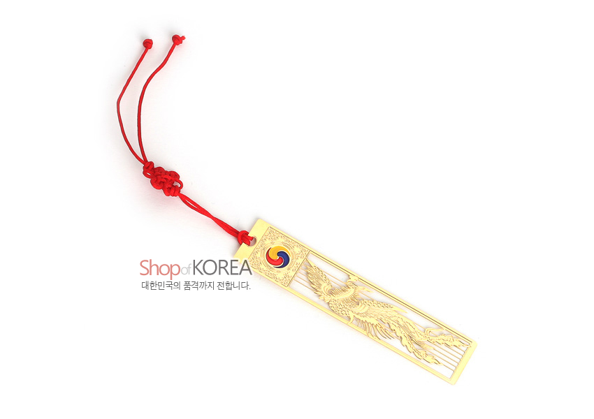 [텍스트: Shop of KOREA 대한민국의 품격까지 전합니다.] 금장 금속 재질 위에 섬세한 봉황 문양을 양각한 직사각 책갈피와 상단 태극 문양, 붉은 전통 매듭 끈 장식 구성