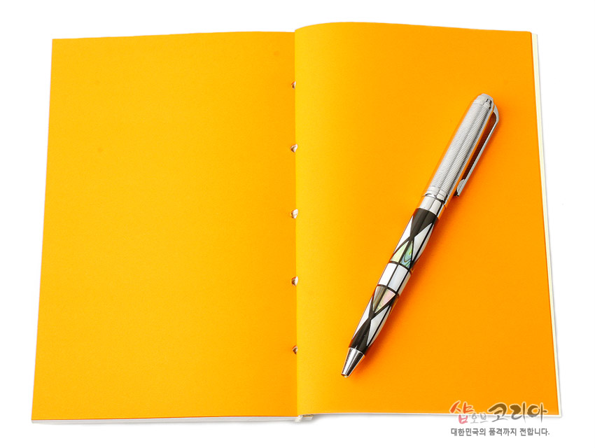 [텍스트: 샵오브코리아 대한민국의 품격까지 전합니다.] 선명한 주황색 내지와 노출 실제본 구조, 자개 상감 기법의 기하학 문양이 들어간 메탈 볼펜 배치된 이미지 설명