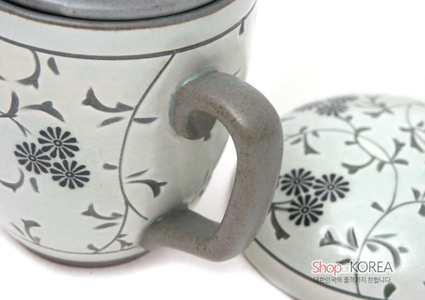 [텍스트: Shop of KOREA 대한민국의 품격까지 전합니다.] 백색 도자기 재질에 회색 손잡이와 뚜껑 구성, 회색 선으로 시문한 국화와 덩굴 문양 장식 머그 다기잔 디테일 이미지