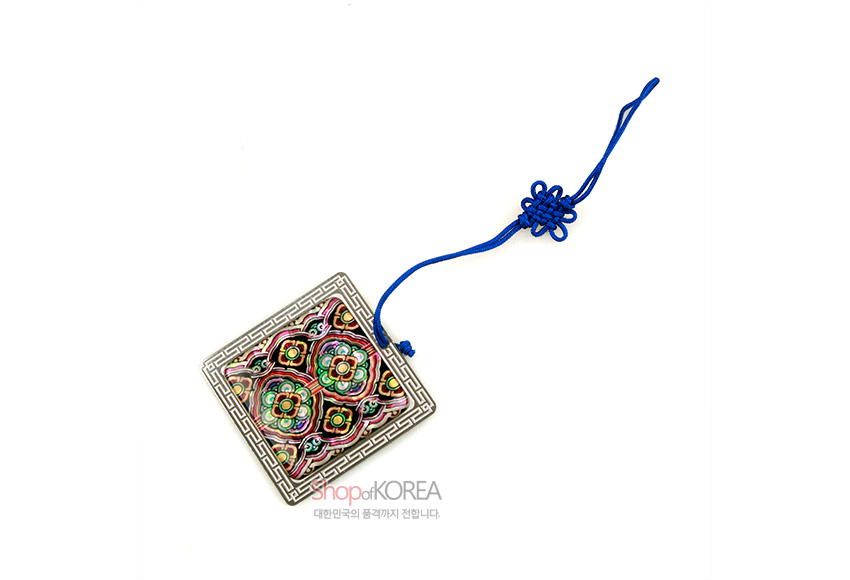 [텍스트: shop of KOREA 대한민국의 품격까지 전합니다] 자개 상감으로 기와단청 꽃문양을 넣은 금속 장식과 청색 전통 매듭끈이 조화된 책갈피 이미지 설명