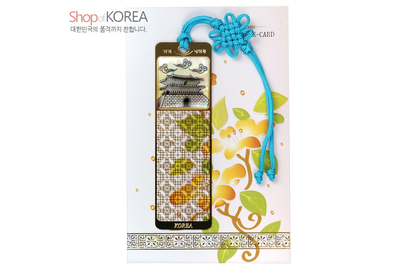 [텍스트: Shop of KOREA / 대한민국의 품격까지 전합니다. / THANK YOU …… BOOKMARK-CARD / 남대문 / KOREA] 금속 바탕 위 자개 상감으로 남대문과 구름, 문살무늬와 단풍잎을 표현하고 청색 전통 매듭끈으로 장식한 책갈피 이미지 설명