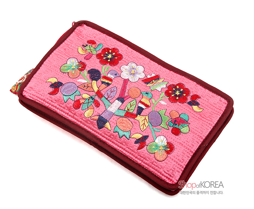 [텍스트: Shop of KOREA 대한민국의 품격까지 전합니다.] 연분홍 비단 누비 바탕에 다채로운 색실로 수복 문자와 꽃, 열매, 잎사귀 문양을 정교하게 수놓은 직사각형 파우치 디자인