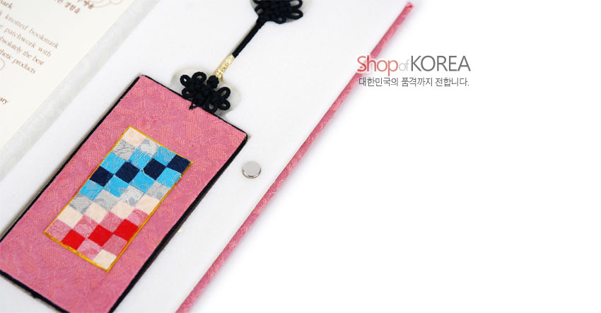 [텍스트: Shop of KOREA, 대한민국의 품격까지 전합니다.] 분홍색 비단 바탕에 청·홍·백색 조각보 패치워크와 검은색 전통 매듭 장식이 더해진 직사각 책갈피 모습