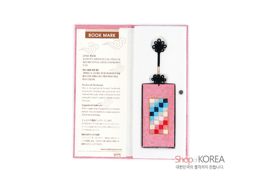 [텍스트: BOOK MARK, Shop of KOREA] 분홍색 비단 바탕 직사각형 위에 빨강·파랑·아이보리 조각보 패치워크, 상단 검은 전통 매듭 장식 구성의 책갈피 디자인