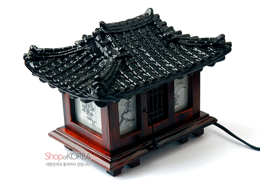 [텍스트: Shop of KOREA / 대한민국의 품격까지 전합니다.] 짙은 갈색 나무와 흑색 기와 지붕으로 표현한 한옥 형태, 반투명 창호지에 수묵화 산수와 초화 문양이 담긴 전통 좌등 스탠드형 조명등