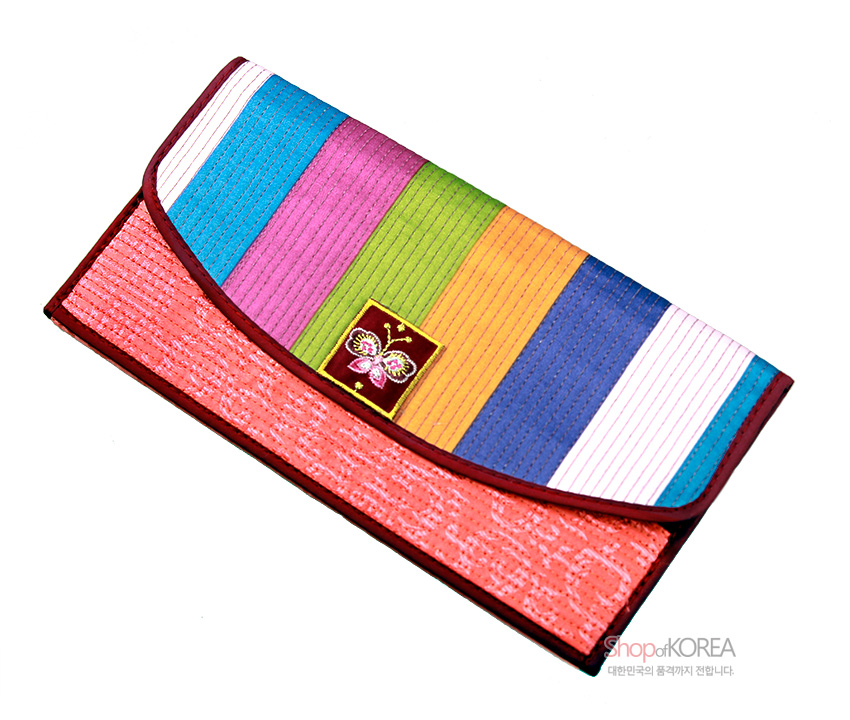 [텍스트: Shop of KOREA 대한민국의 품격까지 전합니다.] 색동 비단 원단 위 세로 누비 기법 적용, 중앙 나비 자수 장식과 담주색 비단 소재 조화가 돋보이는 장지갑 디자인