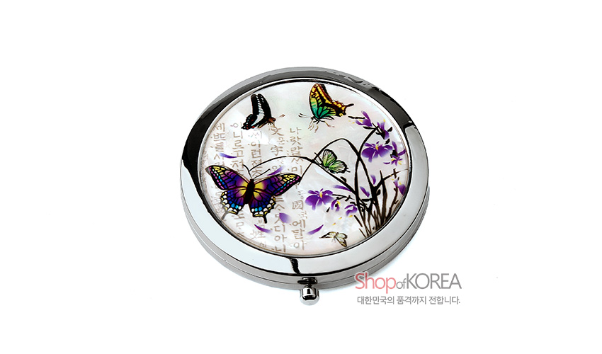[텍스트: Shop of KOREA, 대한민국의 품격까지 전합니다.] 진주빛 자개 바탕 위 난초와 다채로운 나비 문양을 상감한 원형 금속 테두리 원터치 손거울 디자인