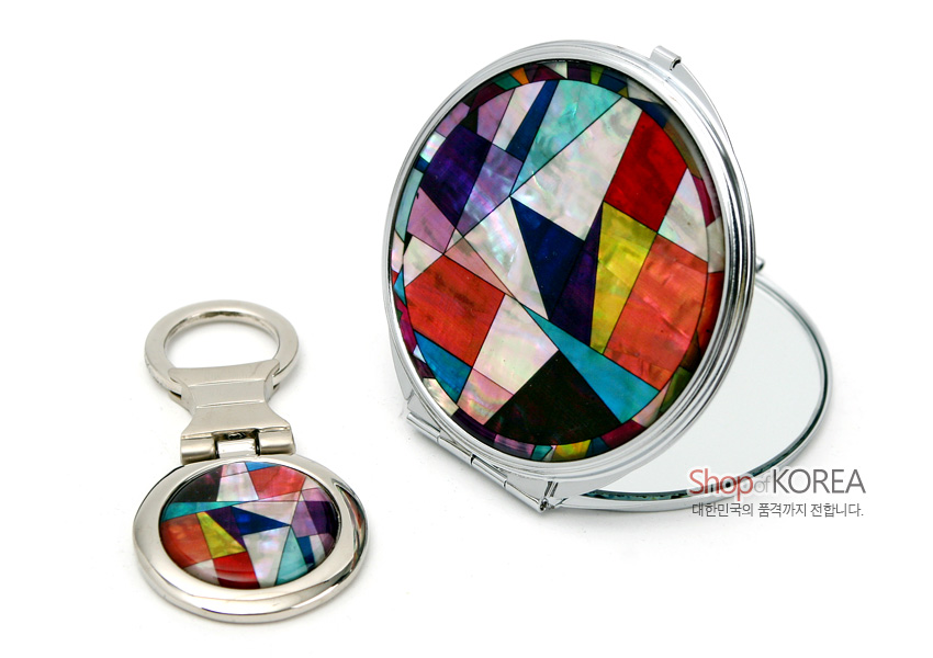 [텍스트: Shop of KOREA 대한민국의 품격까지 전합니다.] 금속 테두리에 다채로운 색상의 조각보 기하학 문양을 자개 상감으로 장식한 원형 손거울과 열쇠고리 세트 이미지 설명