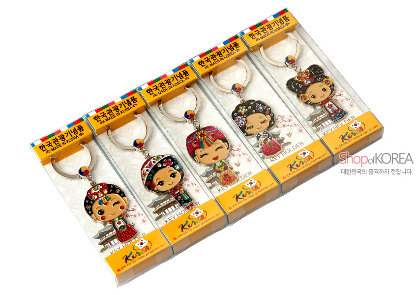 [텍스트: 한국관광기념품 · MADE IN KOREA · KEY HOLDER] 금속 소재에 붉은색·파란색 에나멜 채색된 한복 인형 열쇠고리, 태극 문양 장식과 전통 꽃무늬 포인트의 5종 세트 구성