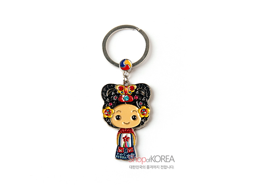 [텍스트: Shop of KOREA, 대한민국의 품격까지 전합니다.] 금속 재질 위에 붉은색·파란색 에나멜 채색, 태극 문양 장식과 화려한 전통 혼례 한복 문양 캐릭터 열쇠고리 디자인描写