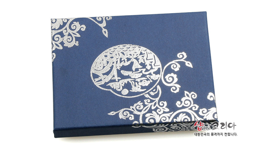 [텍스트: 샵오브코리아 대한민국의 품격까지 전합니다.] 남색 바탕에 은빛 수렵도와 연화문을 인쇄한 종이 재질 포장 박스 모습