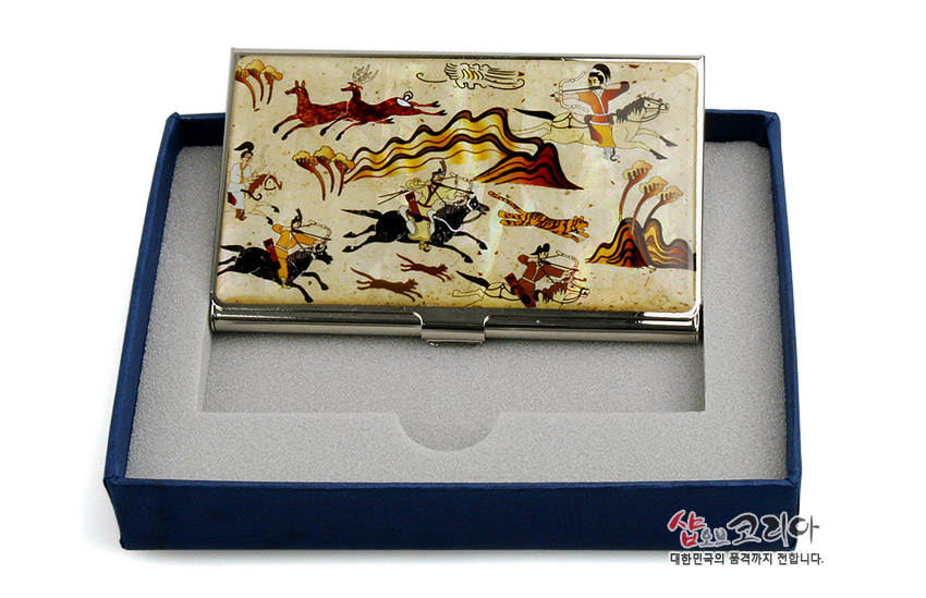 [텍스트: 샵오브코리아 대한민국의 품격까지 전합니다.] 은은한 베이지 바탕 자개 위에 붉은·노랑·검정 색조로 무용총 수렵도 인물과 동물 문양을 그린 금속 테두리 명함집 디자인