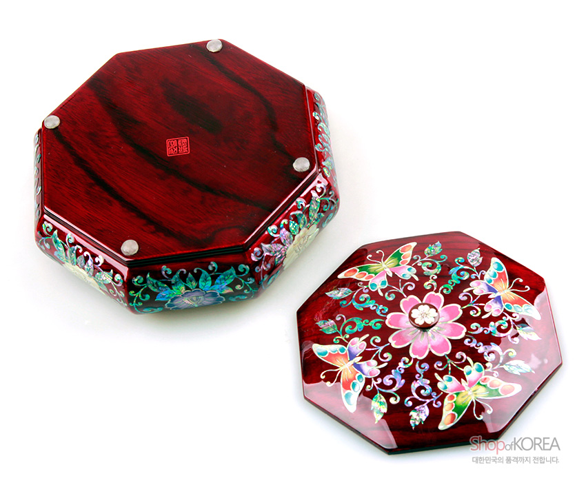 [텍스트: Shop of KOREA 대한민국의 품격까지 전합니다.] 붉은 옻칠 바탕 위 자개 상감 기법으로 표현한 팔각형 나전칠기함, 꽃과 나비 문양의 다채로운 색채 장식 표현