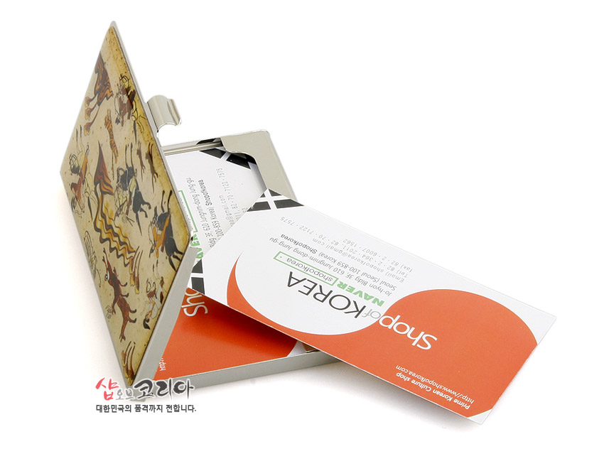 [텍스트: 샵오브코리아 대한민국의 품격까지 전합니다.] 금속 재질 명함케이스에 수렵도 풍속화 문양을 인쇄한 뚜껑 디자인과 내부 명함 수납 구조 표현