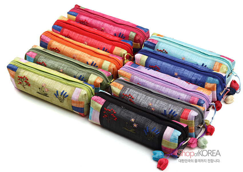 [텍스트: ShopofKOREA 대한민국의 품격까지 전합니다.] 다양한 색상의 모시 소재 필통, 꽃 자수 문양과 색동 배색, 매듭 노리개 장식이 조화된 지퍼형 디자인
