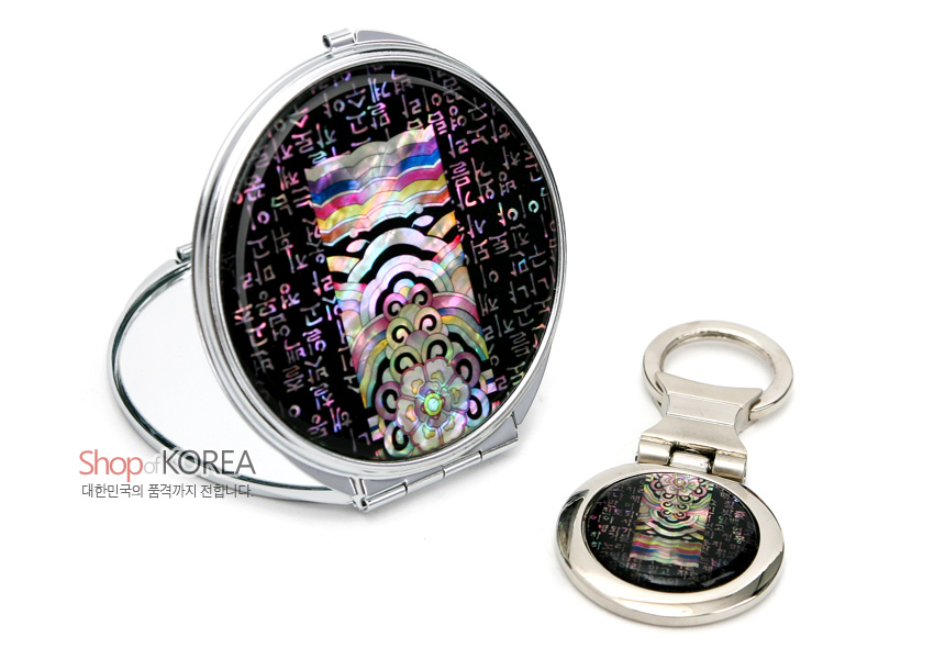 [텍스트: Shop of KOREA 대한민국의 품격까지 전달합니다.] 칠흑색 바탕 위 금속 테두리에 자개 상감 기법으로 다채로운 단청 문양과 한글 시조 글자를 배치한 손거울과 열쇠고리 세트 구성