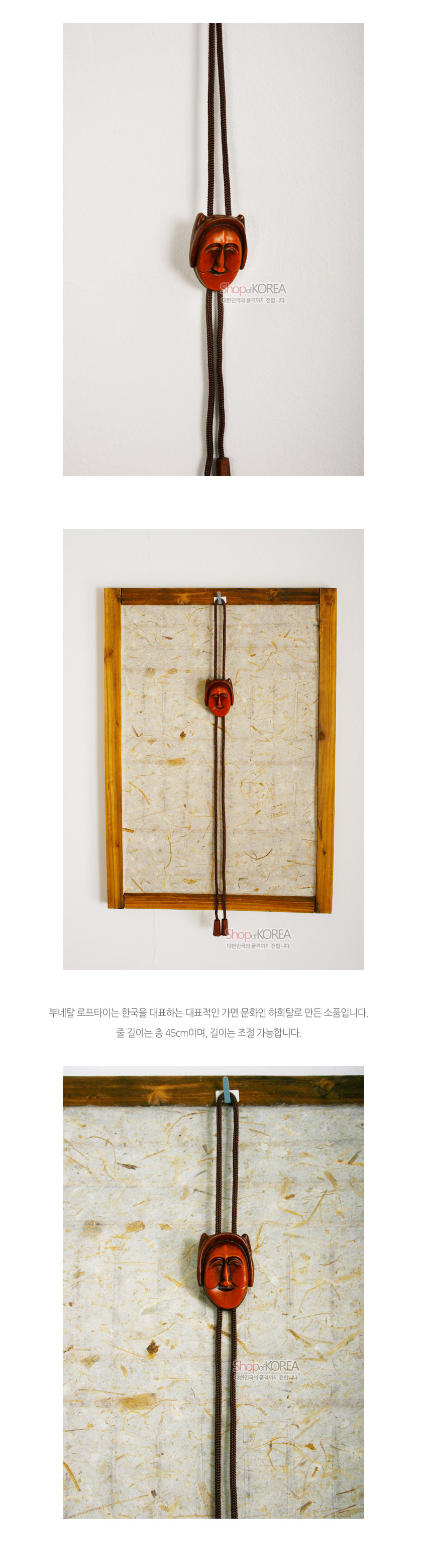 [텍스트: ShopofKOREA 대한민국의 품격까지 전합니다 부네탈 로프타이는 한국을 대표하는 대표적인 가면 문화인 하회탈로 만든 소품입니다. 줄 길이는 총 45cm이며, 길이는 조절 가능합니다.] 갈색 목재로 조각한 부네탈 장식과 짙은 갈색 끈이 어우러진 전통 로프타이 형태의 장신구 연출
