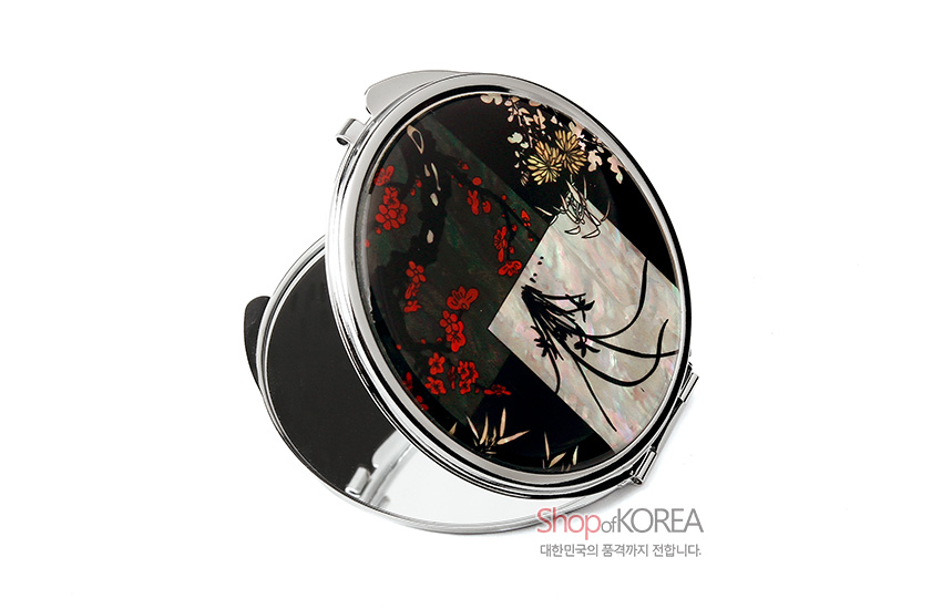 [텍스트: Shop of KOREA 대한민국의 품격까지 전합니다.] 자개 상감 기법의 사군자 문양 원형 금속 손거울, 검은 옻칠 바탕에 붉은 매화와 난초·국화가 어우러진 디자인