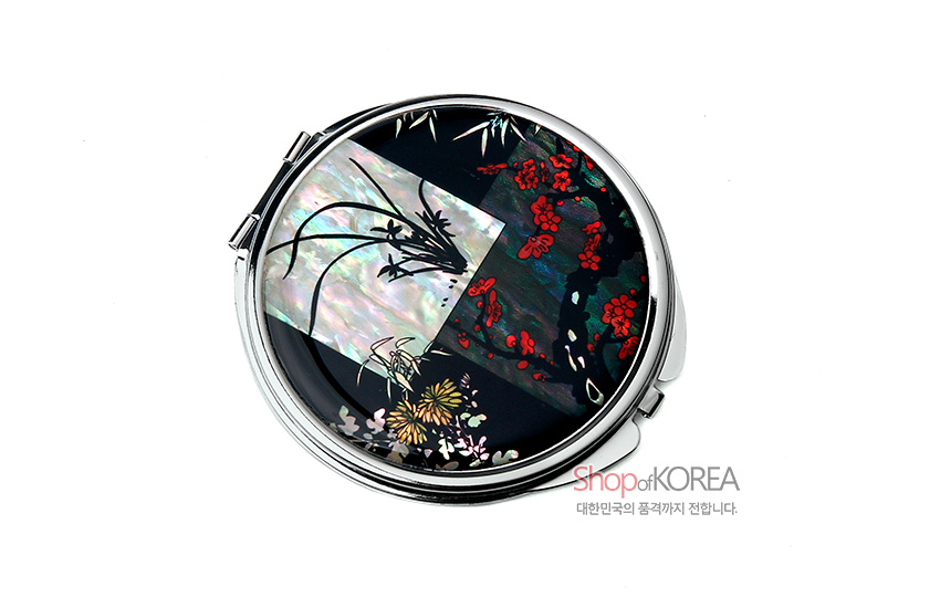 [텍스트: Shop of KOREA 대한민국의 품격까지 전합니다.] 금속 테두리에 흑색 옻칠과 자개 상감 기법으로 사군자 문양을 배치한 원형 손거울 디자인