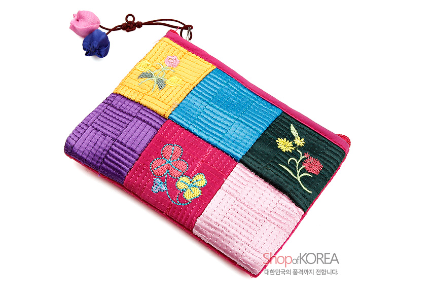 [텍스트: Shop of KOREA 대한민국의 품격까지 전합니다.] 분홍 테두리에 노랑·파랑·보라·초록·연분홍 비단 조각을 누비 기법으로 이어 붙이고 꽃 자수 문양과 꽃봉오리 매듭 장식을 더한 조각보 동전지갑 이미지설명