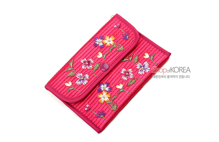 [텍스트: Shop of KOREA 대한민국의 품격까지 전합니다.] 분홍색 누비 원단 위 다채로운 꽃자수 장식과 중앙 똑딱이 단추가 조화로운 직사각형 동전지갑 이미지
