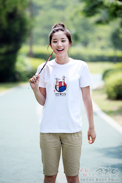 [텍스트: 대한민국의 장승] 흰색 면 소재 티셔츠에 붉은색·남색 태극 문양과 장승 일러스트가 입체감 있게 인쇄된 그래픽 디자인