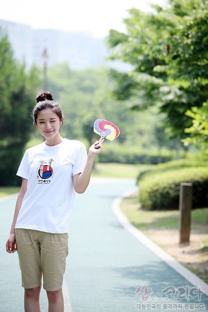 [텍스트: 샵오브코리아 대한민국의 품격까지 전합니다] 흰색 면 티셔츠에 장승 형상과 태극 문양을 발포 인쇄한 3D 입체 그래픽 전통무늬 디자인 이미지