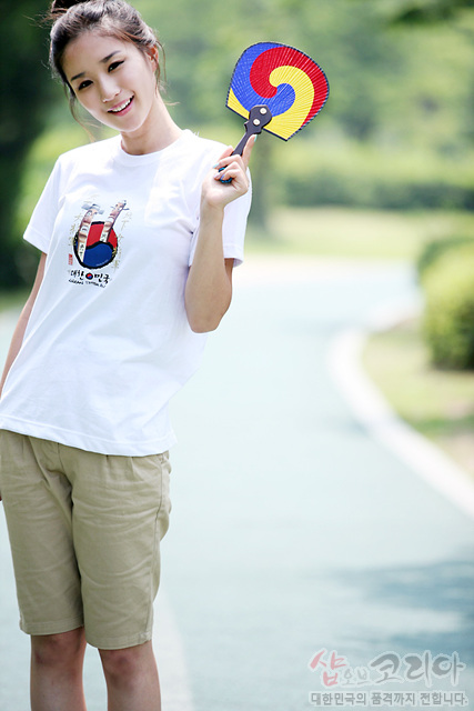 [텍스트: 샵오브코리아 대한민국의 품격까지 전합니다] 흰색 면 티셔츠에 장승 형상과 붉은·파란 태극 문양을 3D 발포 기법으로 표현한 입체 그래픽 디자인