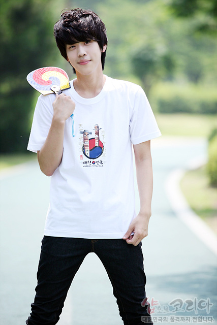 [텍스트: 대한민국] 흰색 면 티셔츠 중앙 장승과 태극 문양의 다색 3D 발포 그래픽, 하단 한글 레터링 장식 디자인