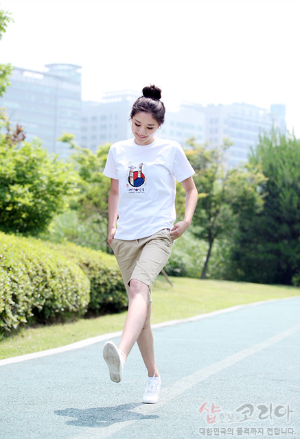 [텍스트: 샵오브코리아 대한민국의 품격까지 전합니다.] 흰색 면 반팔 티셔츠에 장승 형상과 청홍 태극 문양을 3D 입체 발포 프린트로 표현한 캐주얼 디자인 이미지