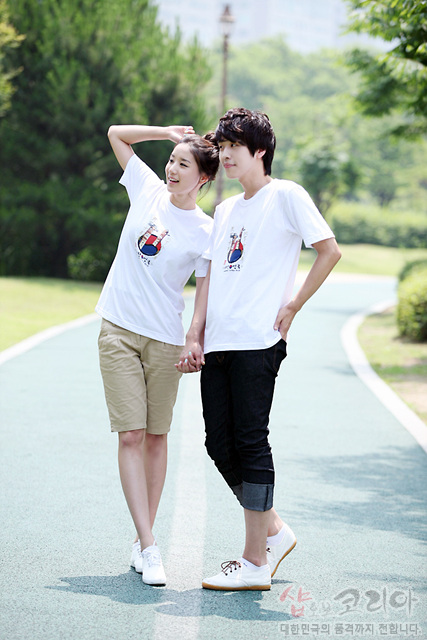 [텍스트: 샵 코리아 대한민국의 종결까지 전합니다] 흰색 면 티셔츠에 장승 형상과 태극 문양을 컬러 인쇄한 3D 발포 그래픽 디자인 연출 이미지