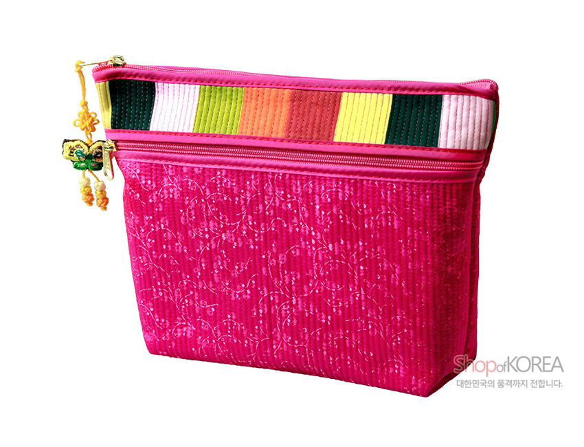 [텍스트: Shop of KOREA 대한민국의 품격까지 전합니다.] 진분홍 누비 비단에 은은한 꽃무늬가 새겨지고, 상단에는 색동 누비 배색과 나비 매듭 장식 지퍼가 더해진 파우치 지갑 디자인