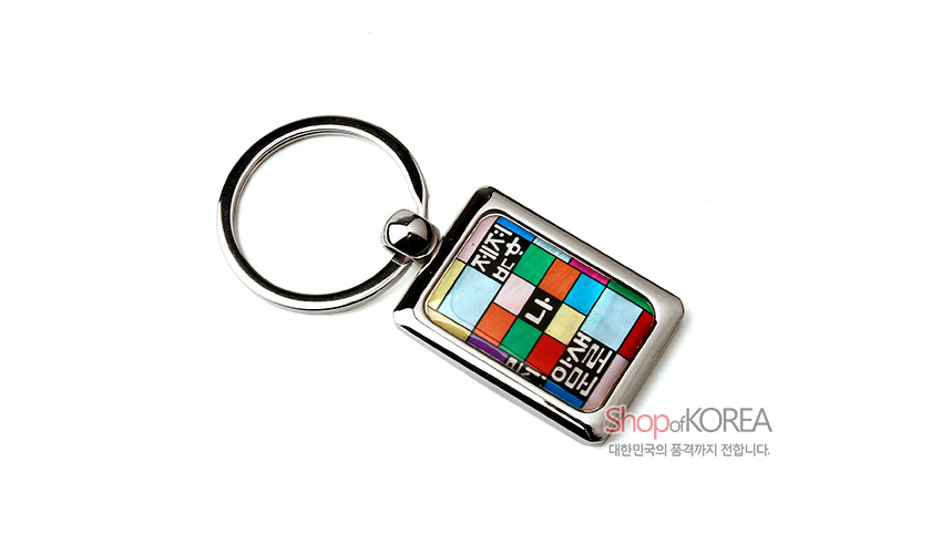 [텍스트: 제자 / 나 / 훈민정음 / Shop of KOREA / 대한민국의 품격까지 전합니다.] 금속 테두리에 자개 상감된 사각 펜던트, 오방색 조각보 배경 위 흑백 훈민정음 문자 배열이 돋보이는 열쇠고리 디자인