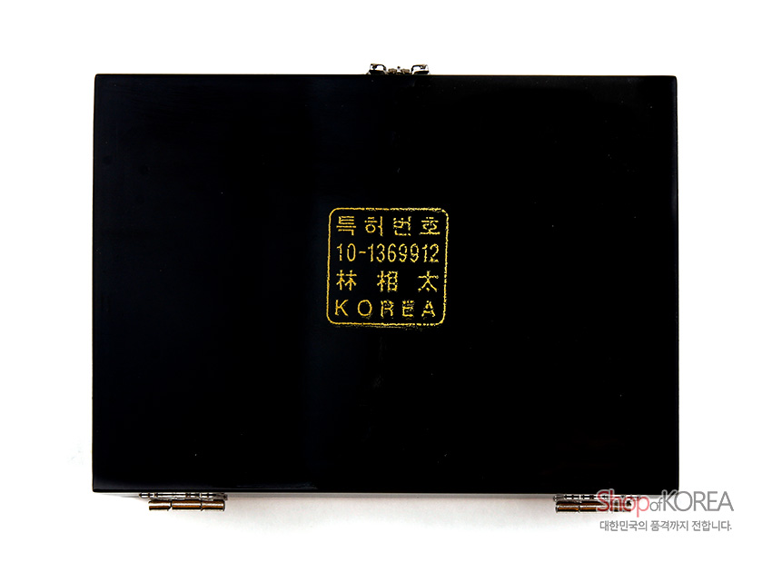 [텍스트: 특허번호 10-1369912 林 相 太 KOREA] 광택 있는 흑색 옻칠 표면 중앙에 금색 각인 로고가 배치된 직사각형 보석함 바닥면 모습