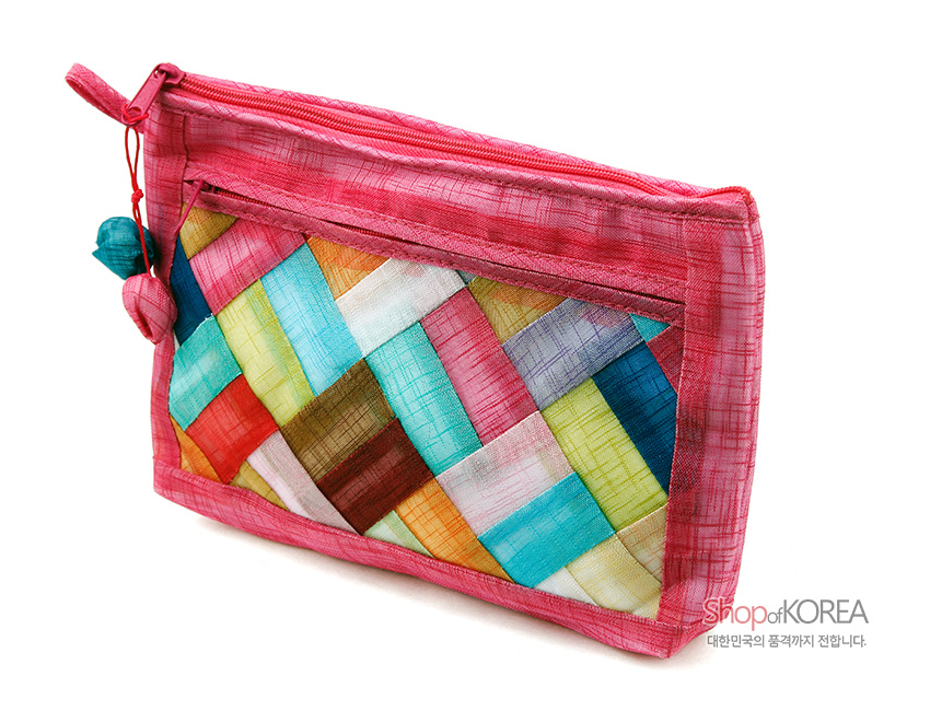 [텍스트: ShopofKOREA 대한민국의 품격까지 전합니다.] 분홍 모시 바탕에 다양한 색상 조각보를 누비 기법으로 장식하고 지퍼와 실타래 장식으로 마무리한 직사각 파우치 디자인