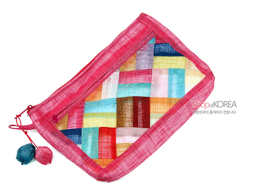 [텍스트: ShopofKOREA 대한민국의 품격까지 전합니다.] 분홍 모시 천 위에 다채로운 색상의 조각보 누비 기법이 더해진 직사각형 지퍼 파우치와 실타래 모양 장식 디테일 표현