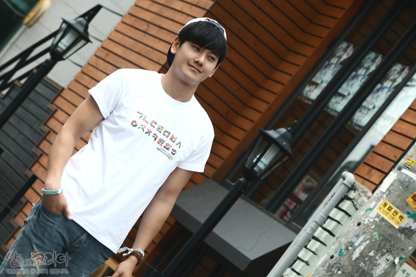 [텍스트: 샵오브코리아] 흰색 면 티셔츠에 다채로운 색감의 한글 자음이 가로로 입체 발포 프린트된 캐주얼 거리 패션 연출 모습