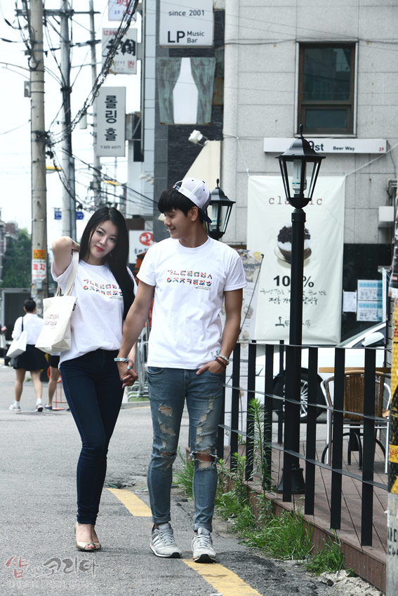 [텍스트: ㄱㄴㄷㄹㅁㅂㅅ ㅇㅈㅊㅋㅌㅍㅎ] 흰색 면 티셔츠 가슴 부분에 다채로운 색상의 한글 자음이 가로로 배열된 입체발포 프린트 디자인 연출