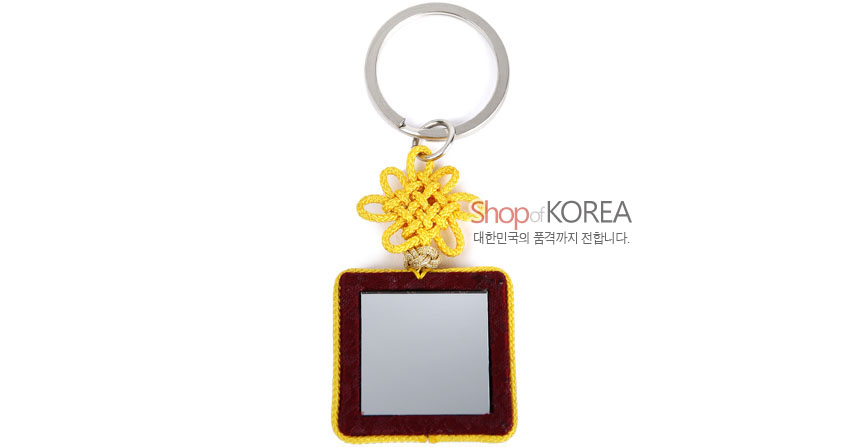 [텍스트: Shop of KOREA 대한민국의 품격까지 전합니다.] 자주색 비단 사각 거울틀과 노란 전통 매듭, 은색 금속 고리가 어우러진 열쇠고리 이미지 설명