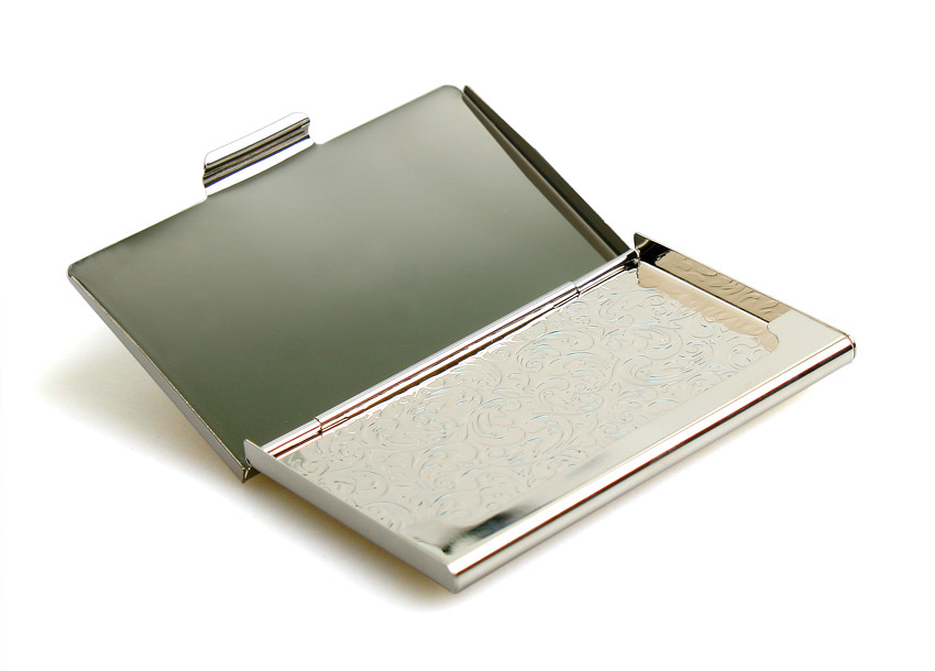 금속 재질로 제작된 명함집 내부, 은은한 광택의 금속 표면과 섬세한 스크롤 문양이 새겨진 바닥면 장식 모습